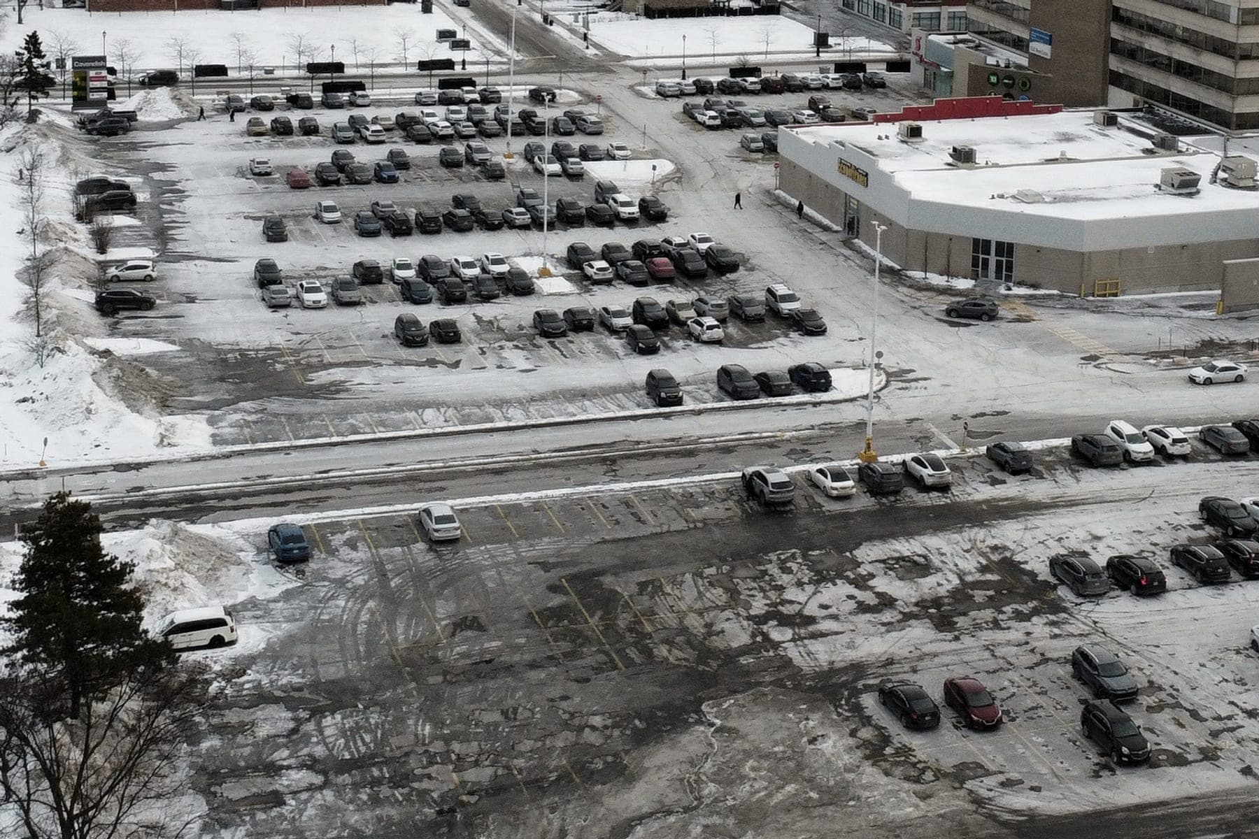 Stationnement commercial déneigé, ses rangées et ses accès dégagés après une chute de neige