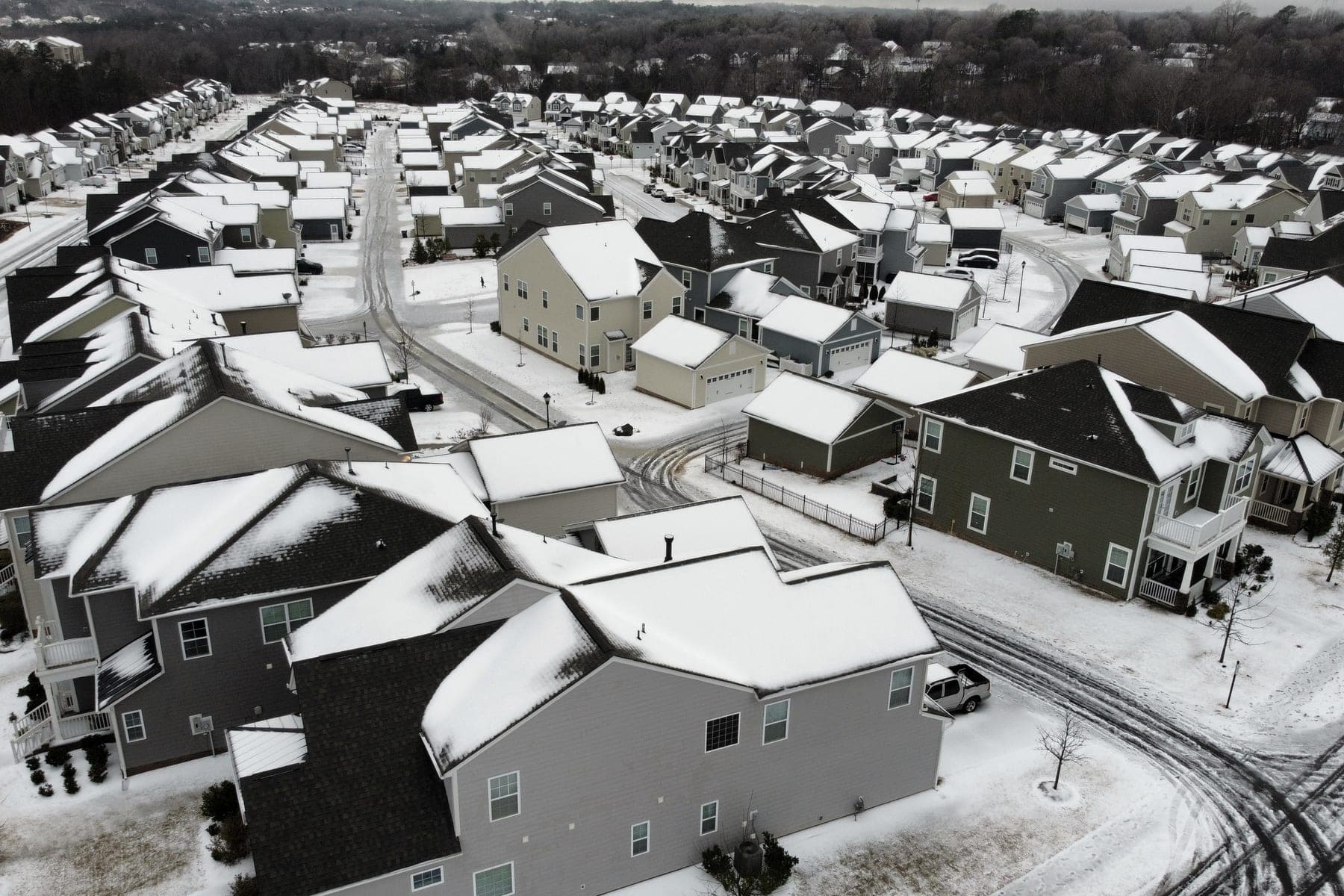 Quartier résidentiel sous la neige, entrées de cour et rue enneigées