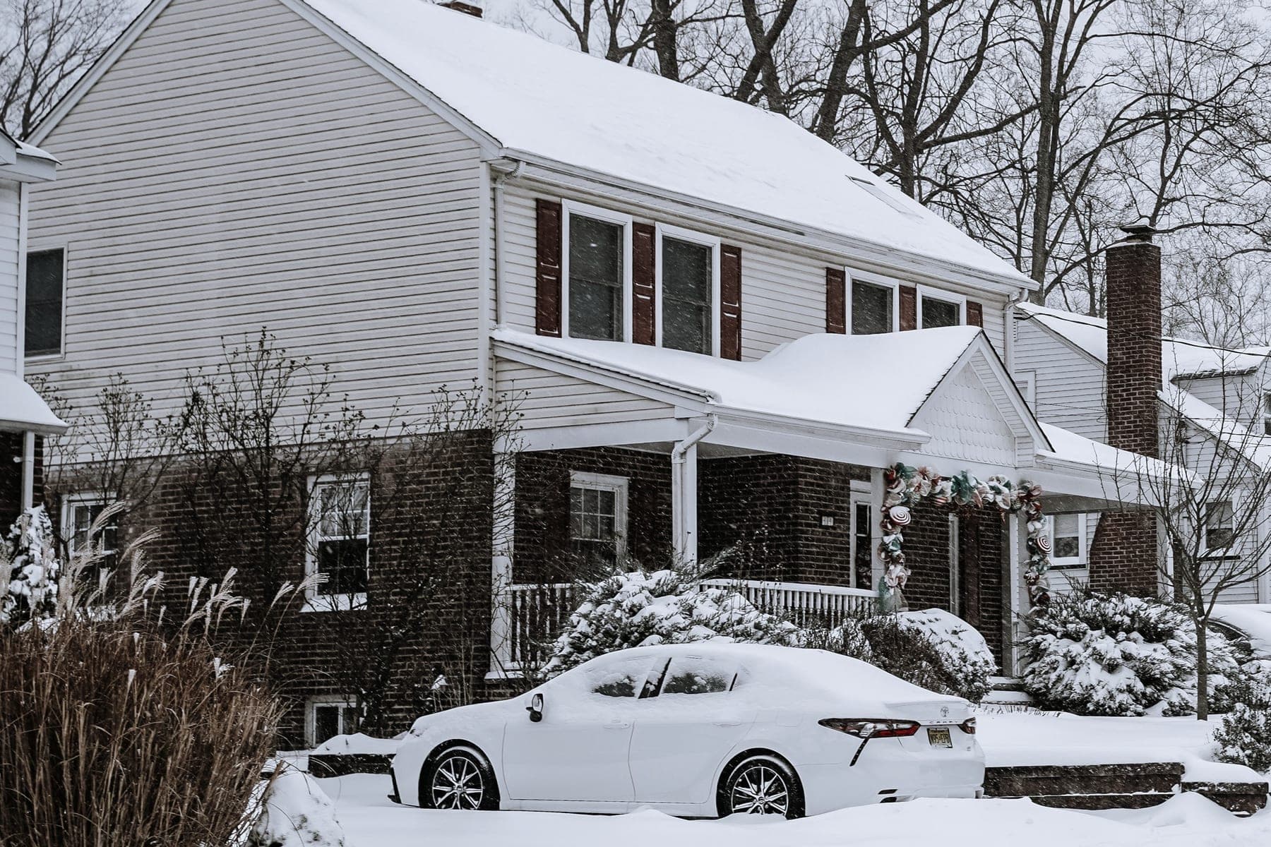 Rue résidentielle sous la neige, maisons et entrées de cour enneigées